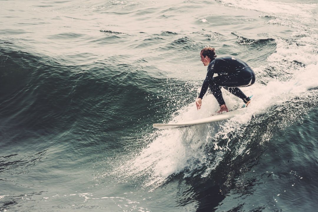 Surf students carrying boards toward a suitable lesson area