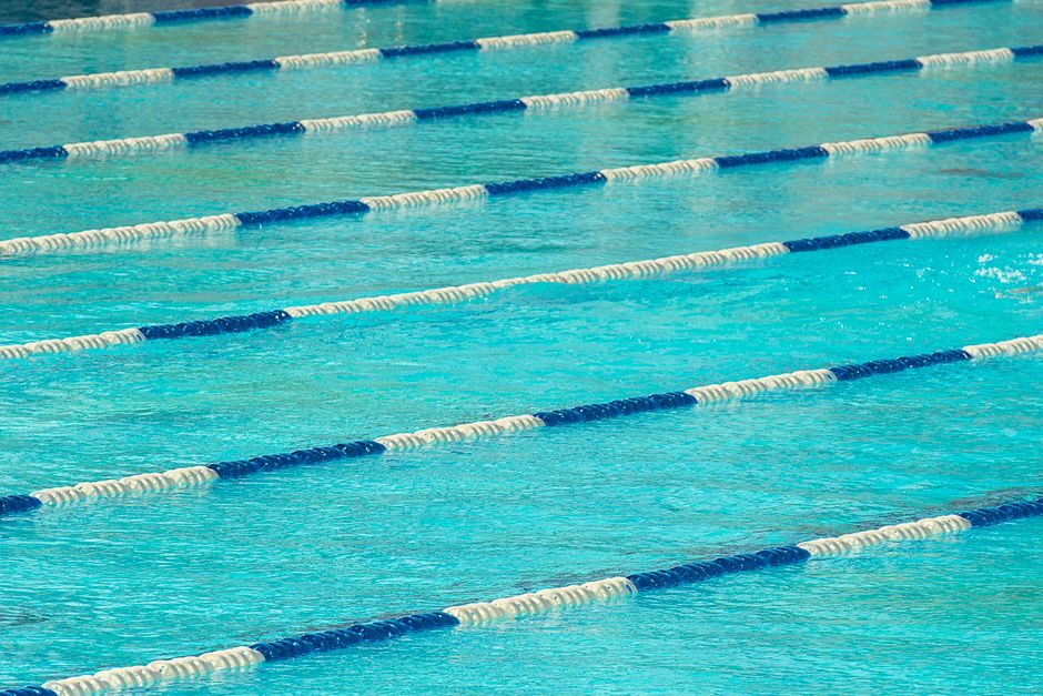 Swim coach explaining a stroke correction at poolside