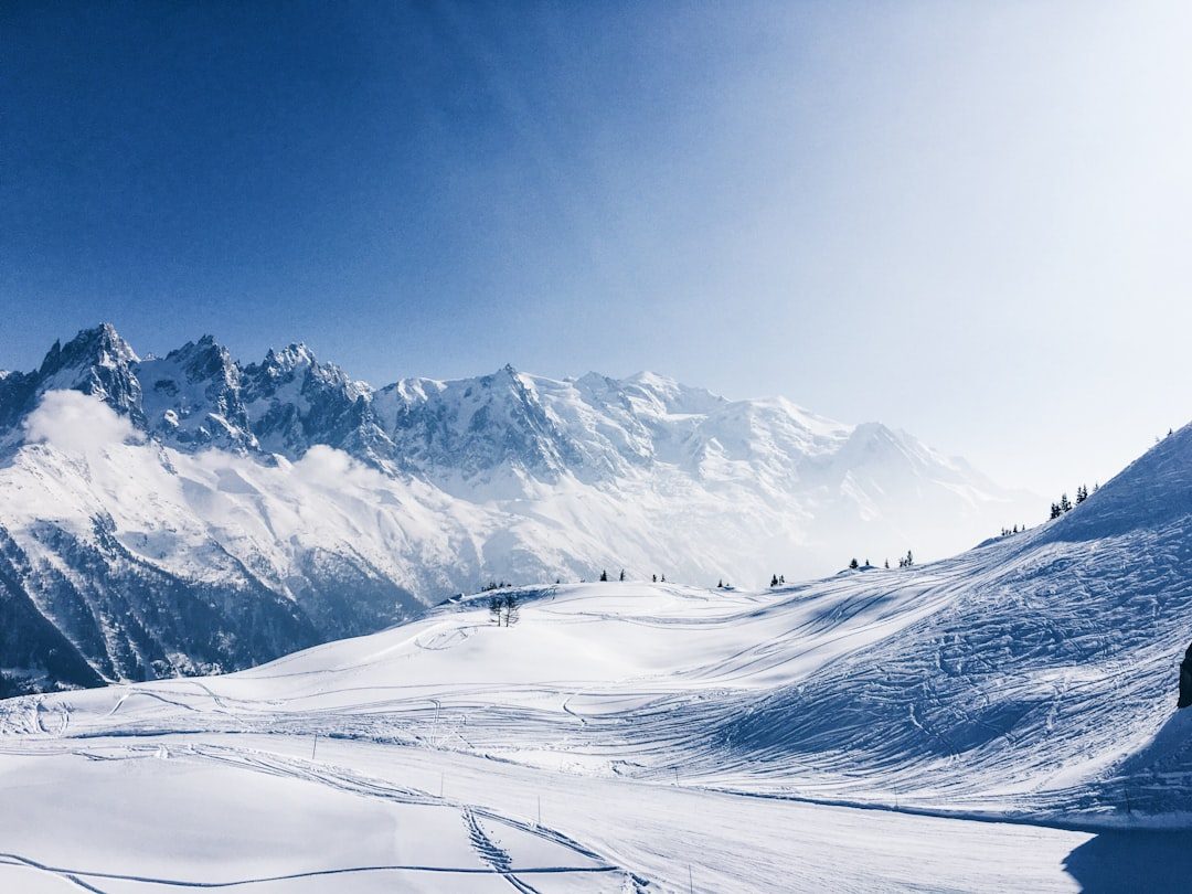 Ski instructor guiding a skier on a groomed alpine slope