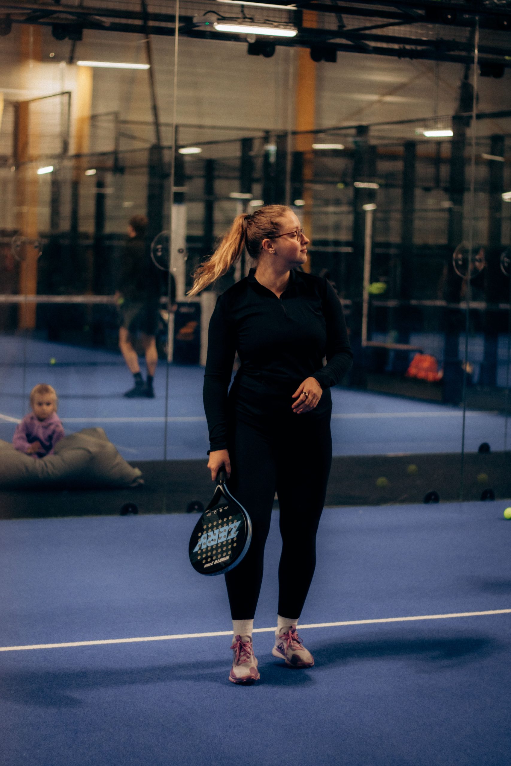 Padel players competing on a panoramic glass court