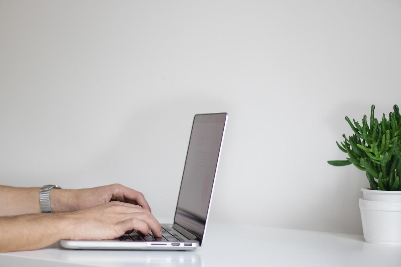 Online fitness coach preparing a workout article on a laptop