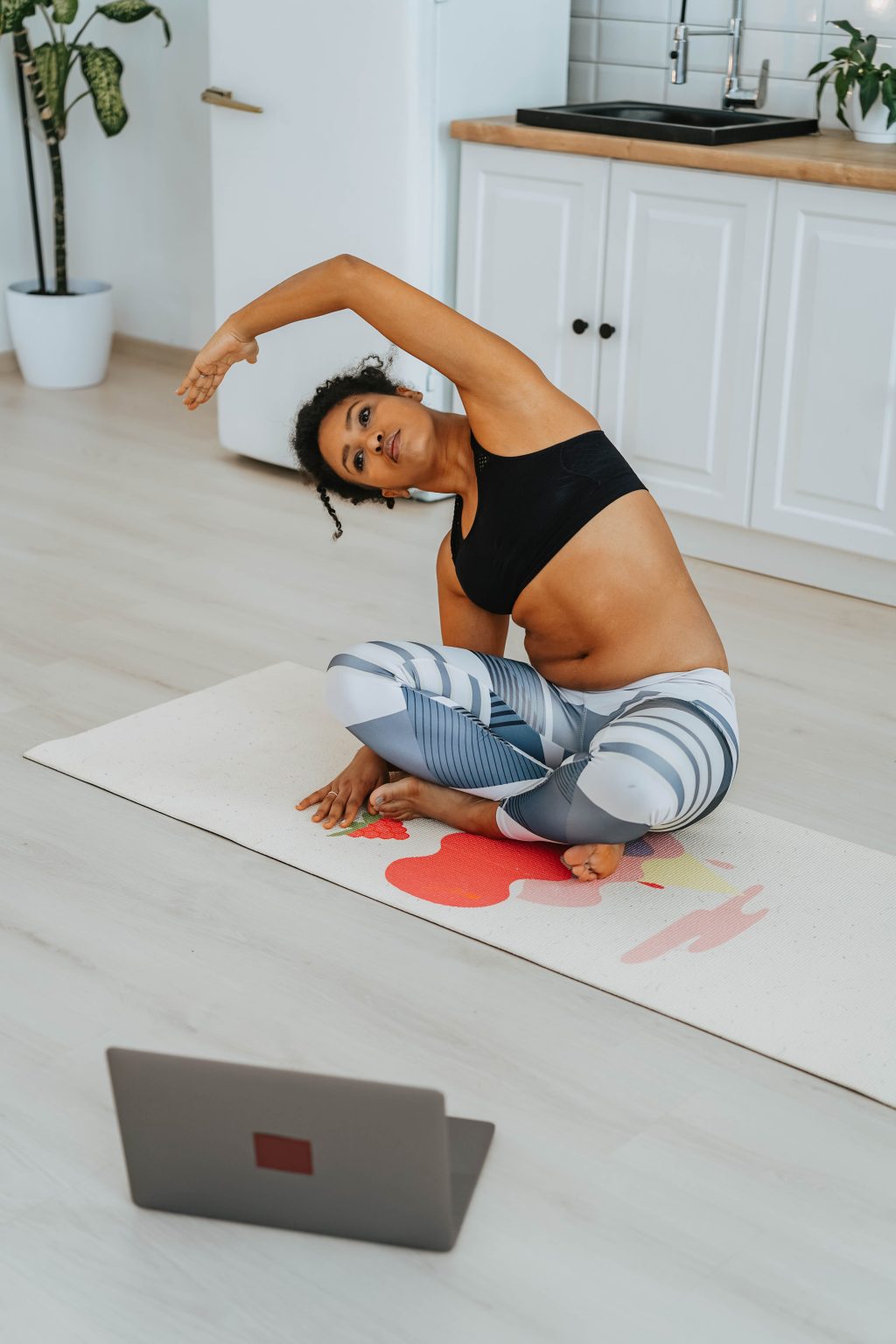 Online fitness coach preparing a workout article on a laptop