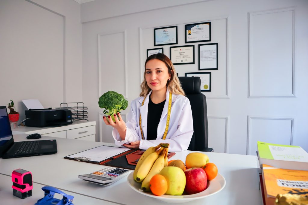 Nutritionist holding broccoli in a professional nutrition office
