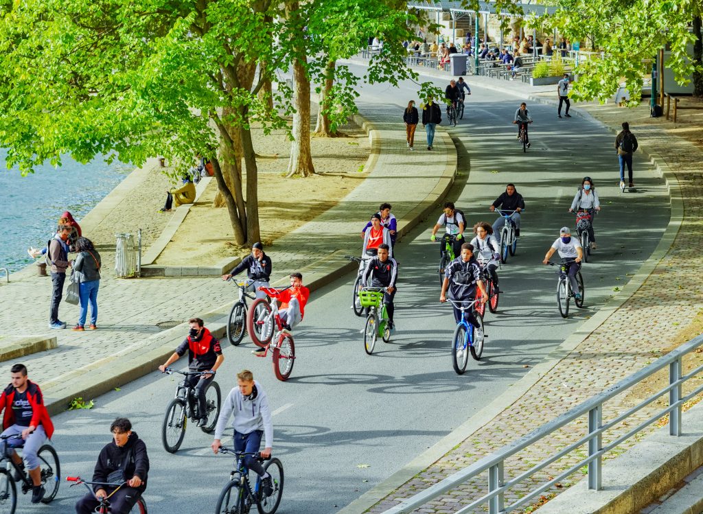 Cyclists riding together beside a city riverside route
