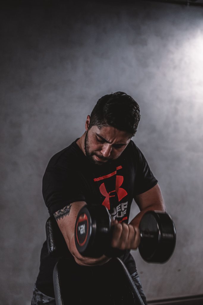 Bodybuilder training with a dumbbell in a gym