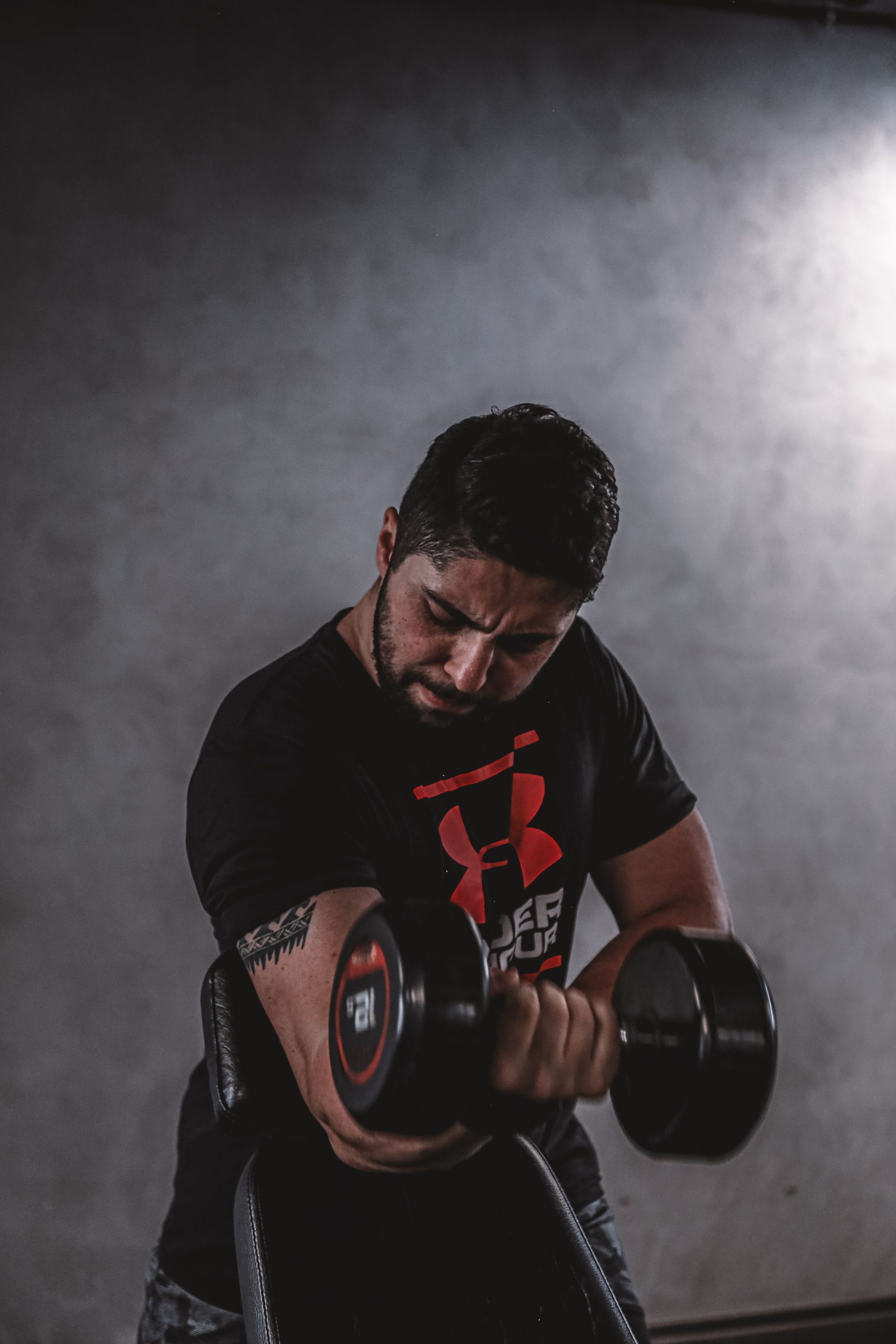 Bodybuilder training with a dumbbell in a gym