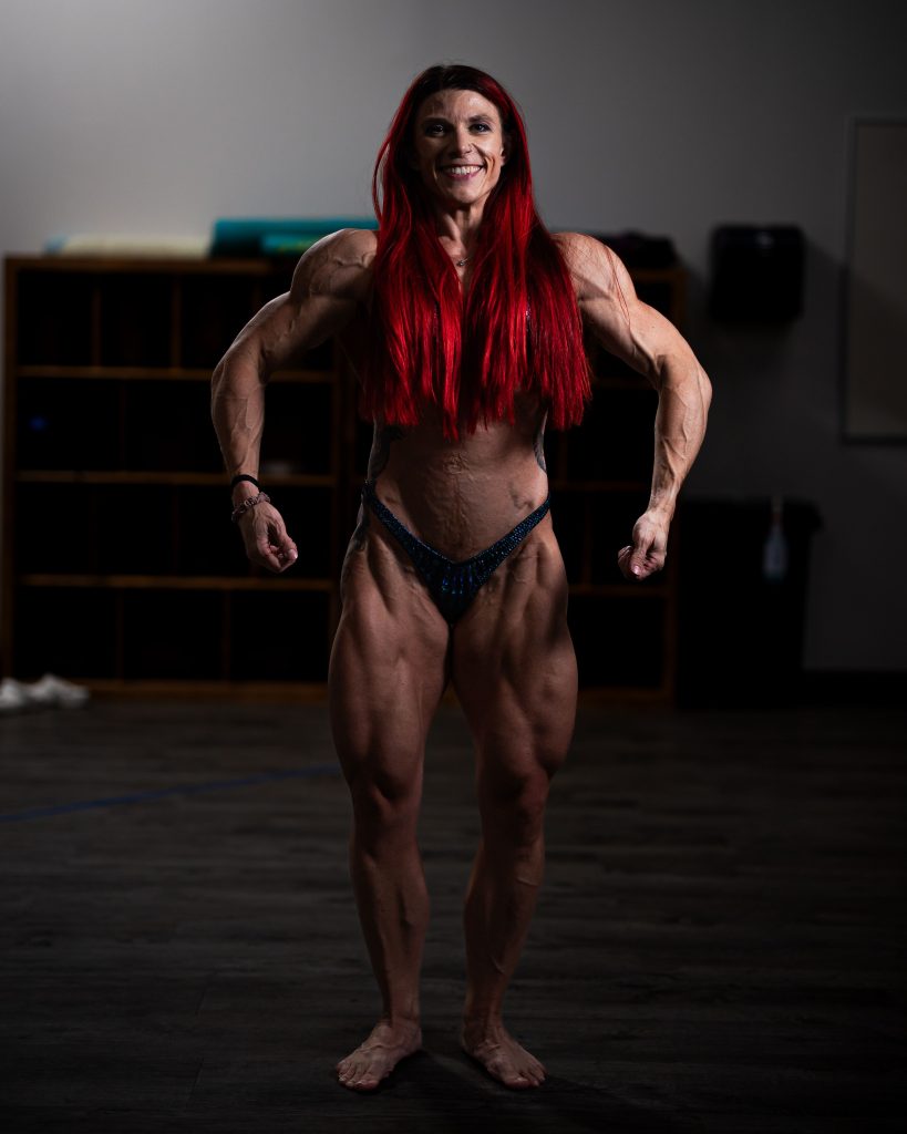Female bodybuilder posing confidently in a gym