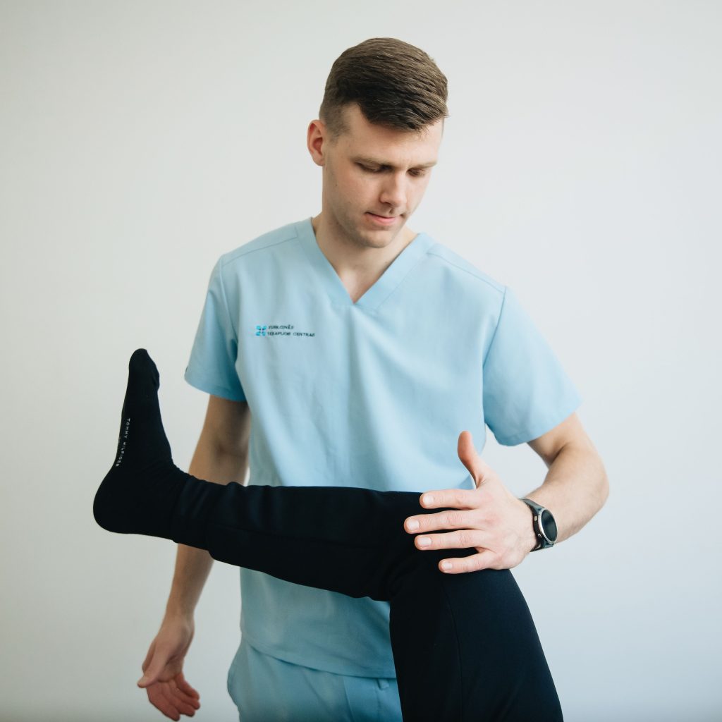Physiotherapist checking knee mobility during rehabilitation