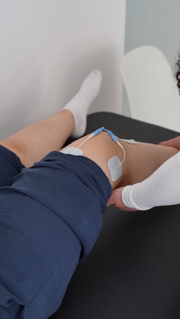 Athlete receiving knee recovery treatment during physiotherapy