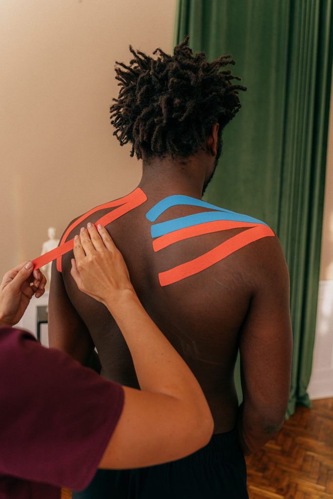 Therapist applying kinesiology tape for sports rehabilitation