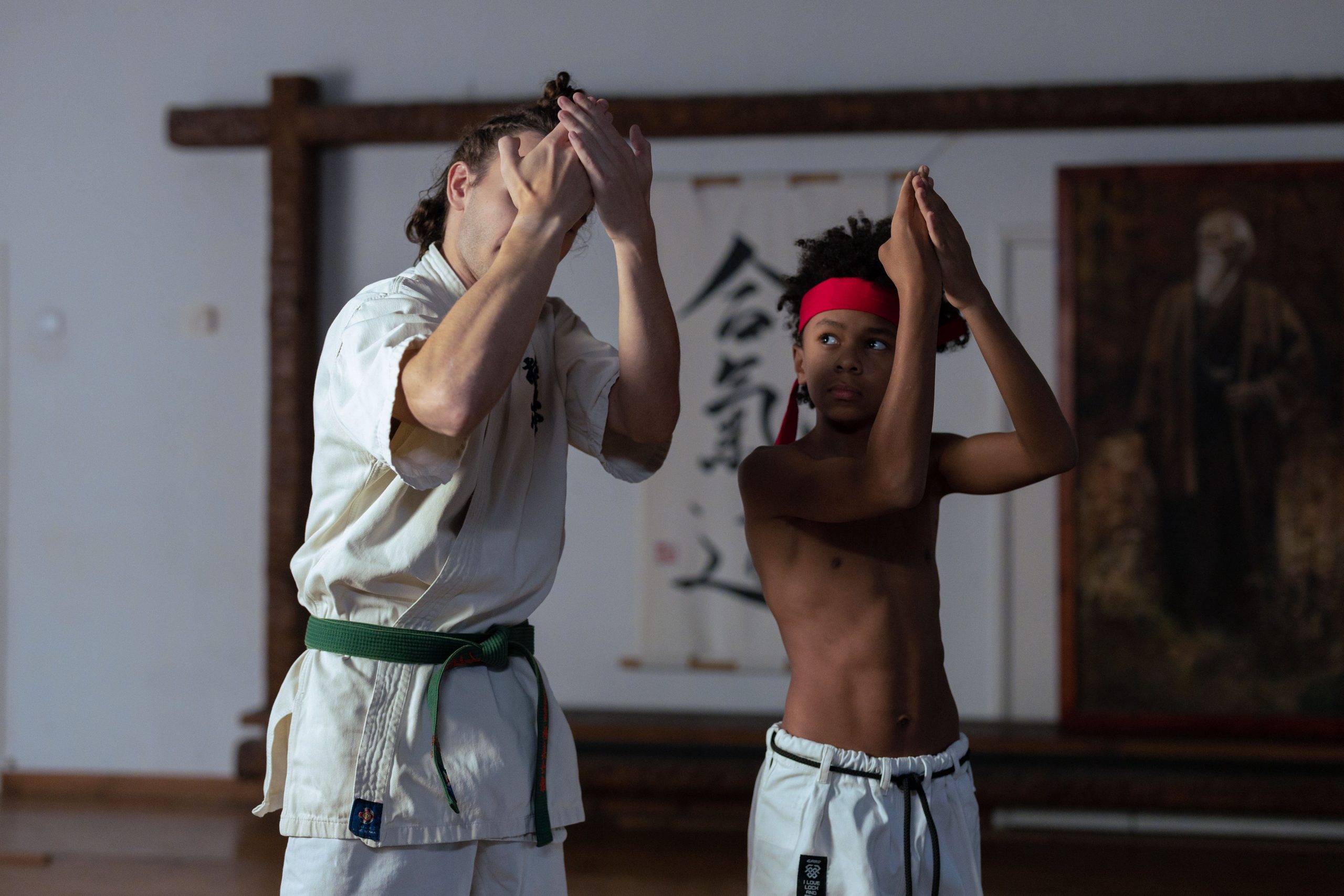 Martial arts coach correcting a student's posture