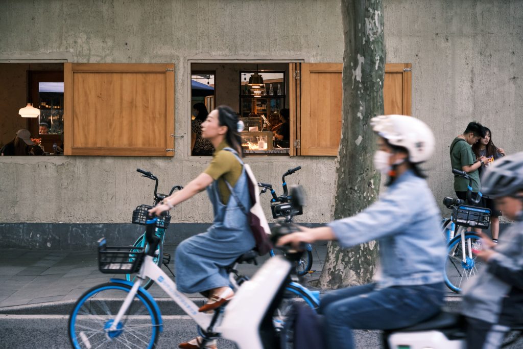 Cyclists passing an outdoor cafe during a social ride
