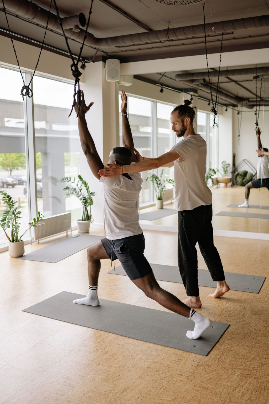 Yoga instructor helping a student with a pose