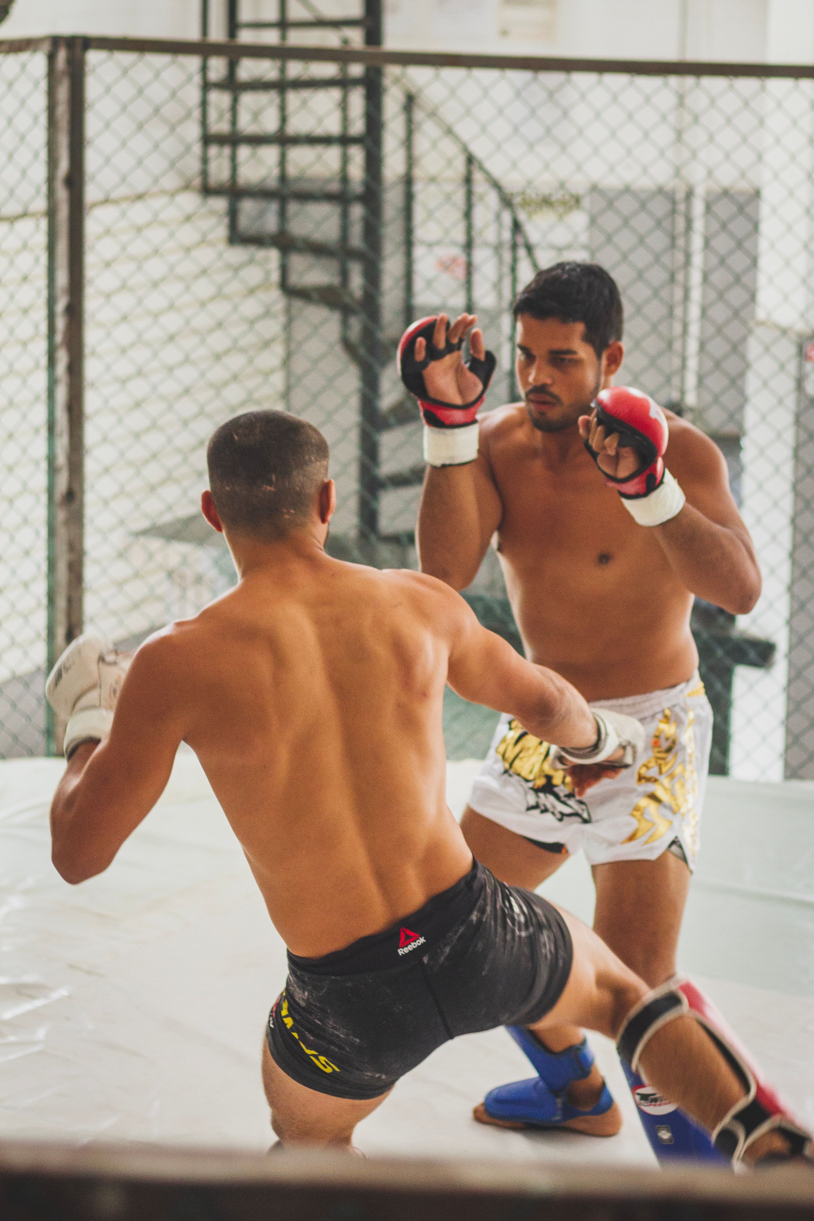 Woman practicing boxing with a trainer in a boxing gym