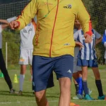 Football academy coach training young players during sports practice