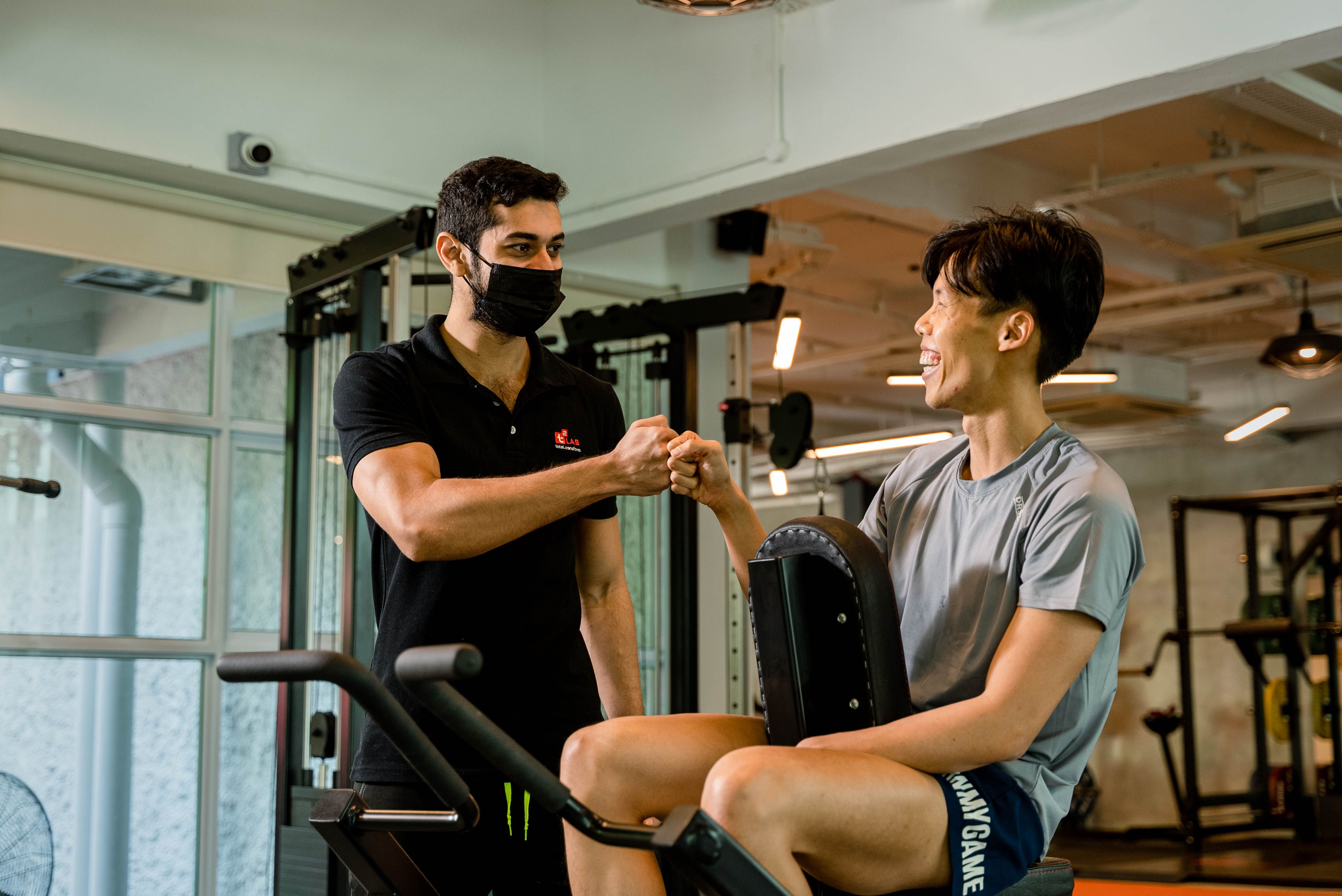 Personal trainer coaching an athlete through a gym workout