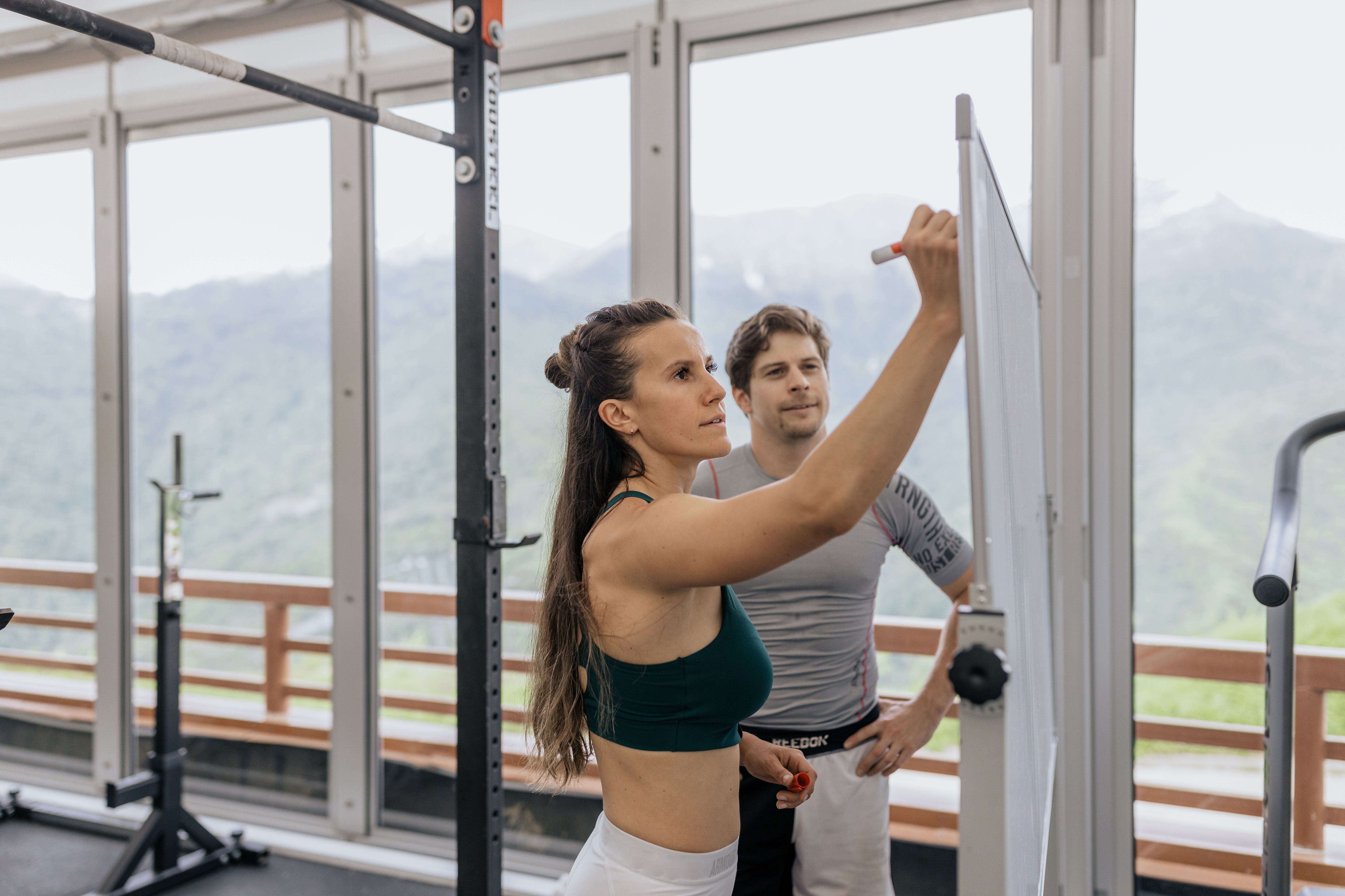 Personal trainer coaching an athlete through a gym workout