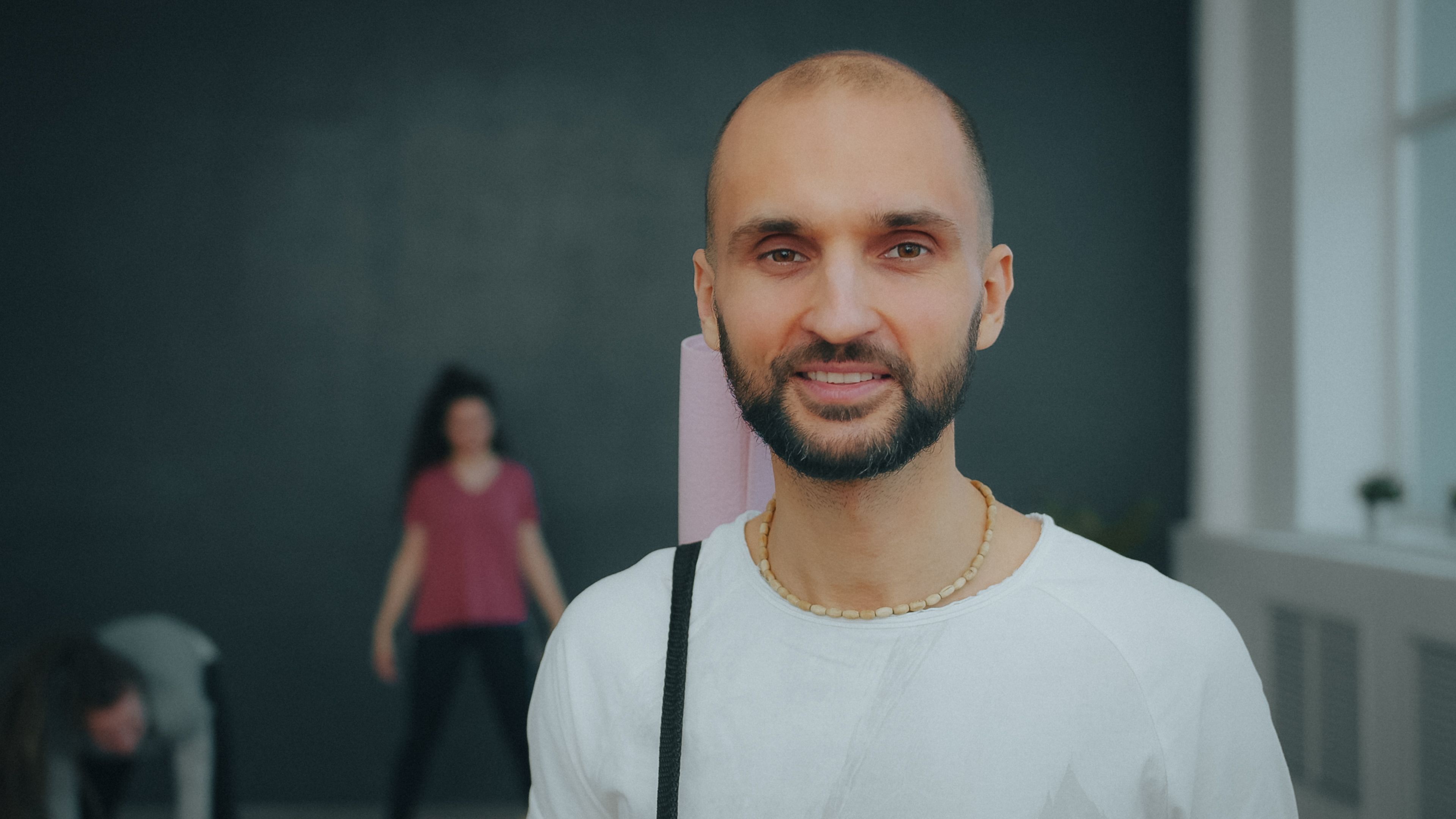 Yoga teacher guiding a student in a studio