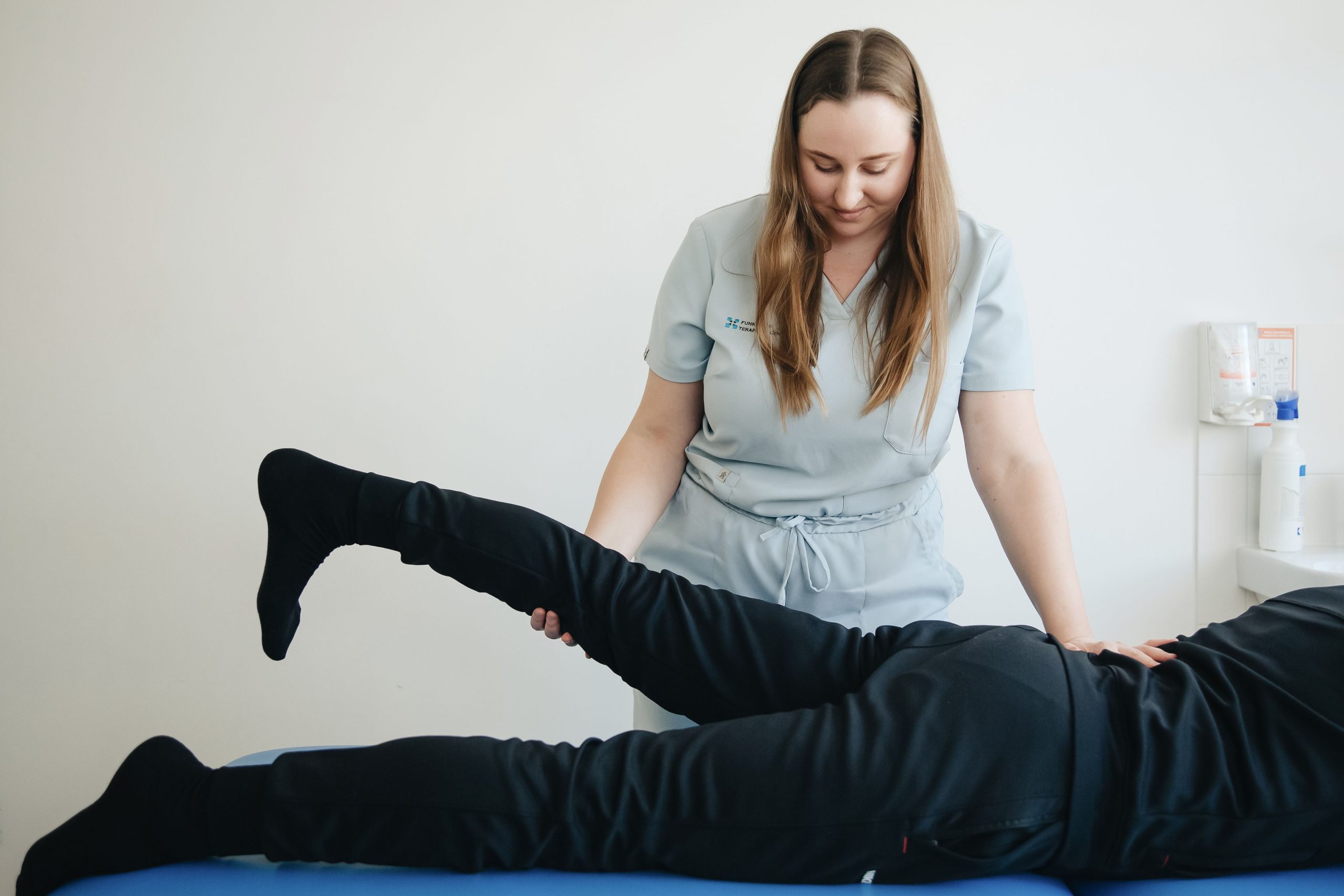 Physiotherapist checking knee mobility during rehabilitation