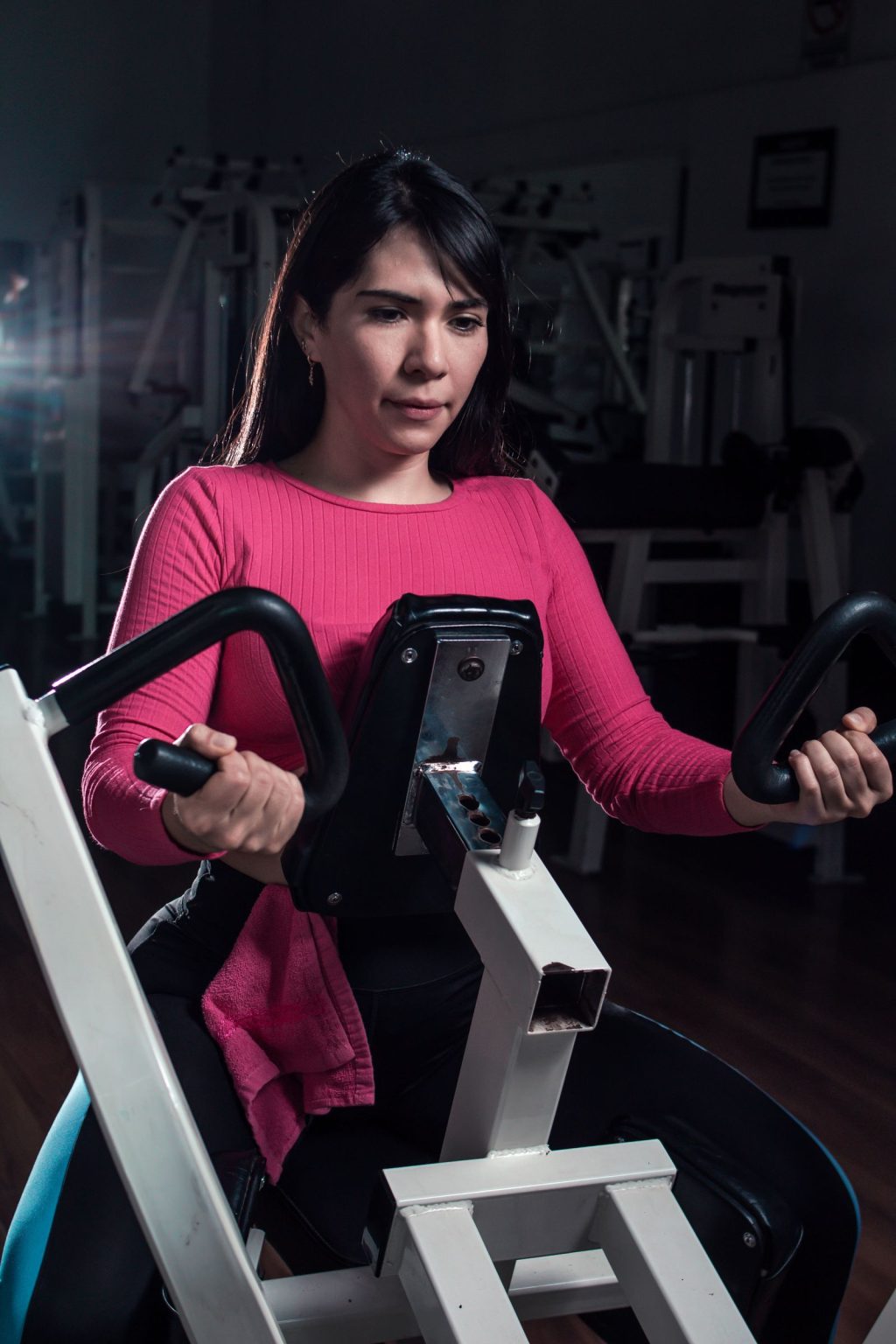 Woman performing strength training on gym equipment