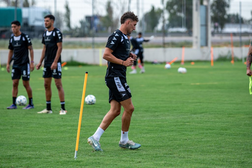 Sports team practicing drills together on a field