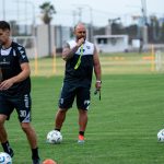Sports coach instructing players during outdoor training