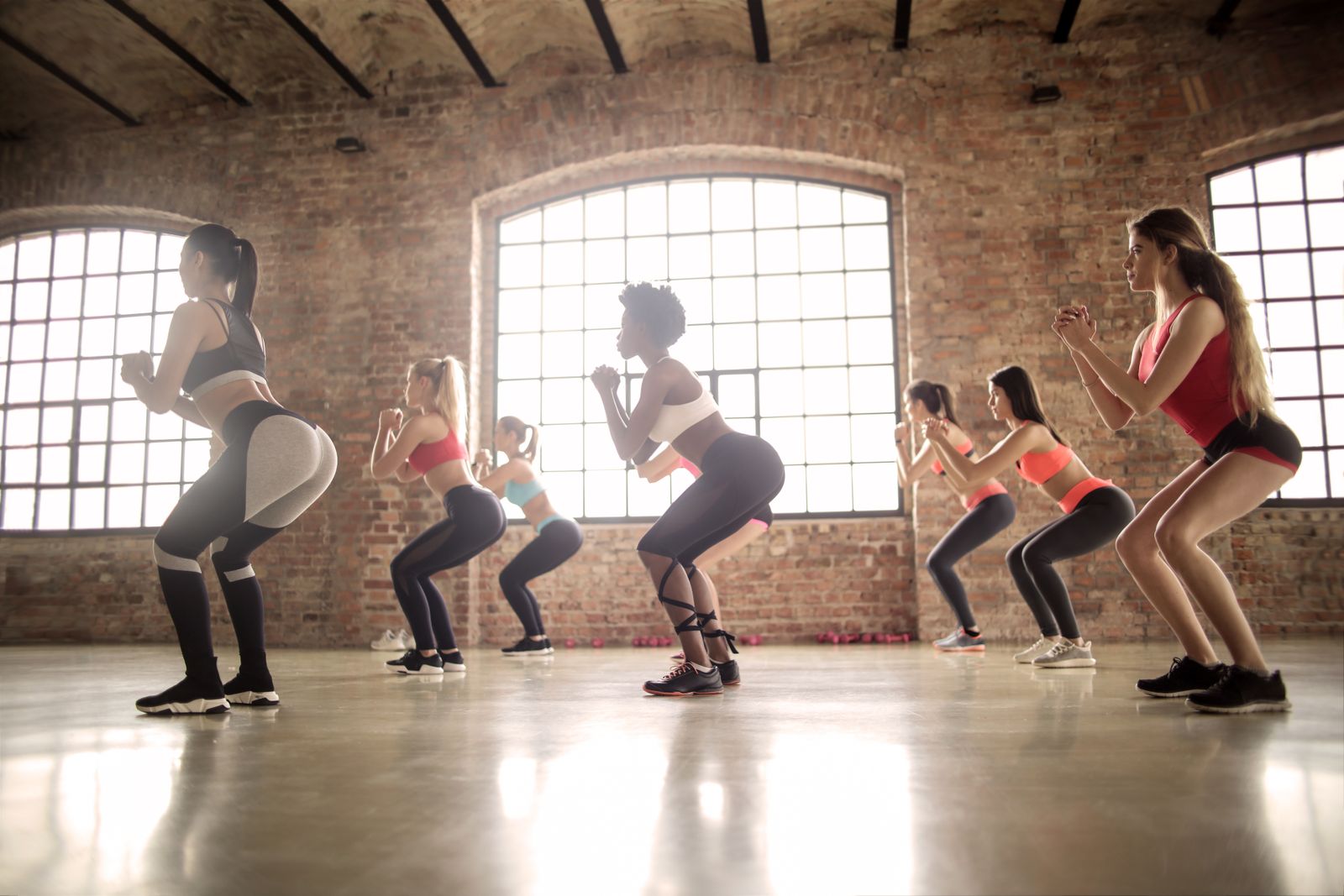 Women performing a coached squat workout