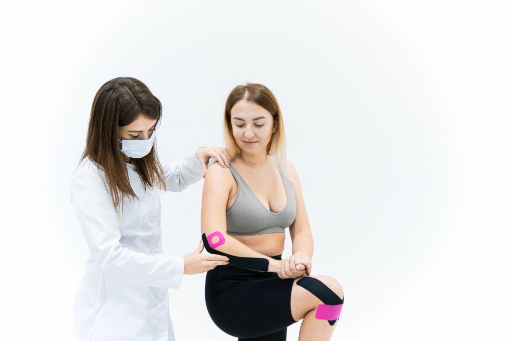 Physical therapist applying athletic tape during rehabilitation