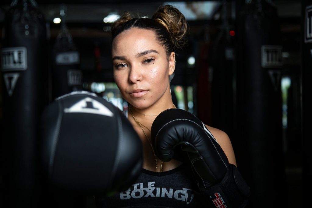 Female boxer training with gloves inside a boxing gym