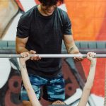 Personal trainer coaching an athlete through a gym workout