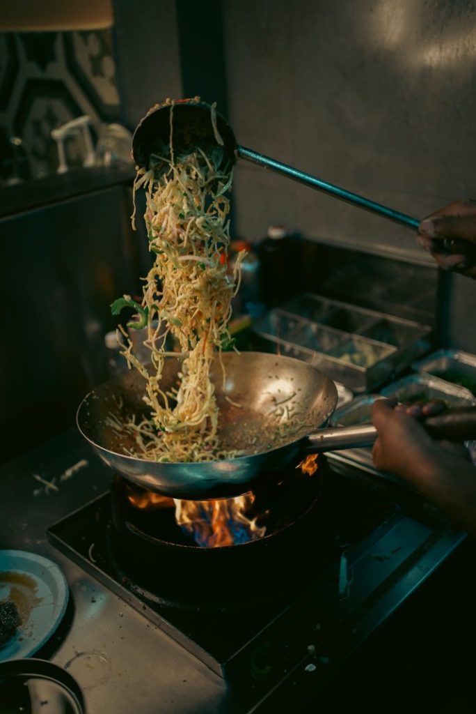 Nexolume Chinese Restaurant & Online Dining chef tossing stir fried noodles in wok