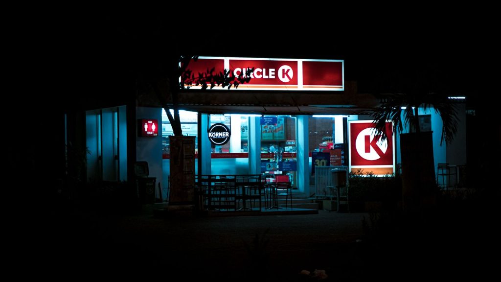 Exterior view of a Circle K store illuminated at night, showcasing vibrant signage.