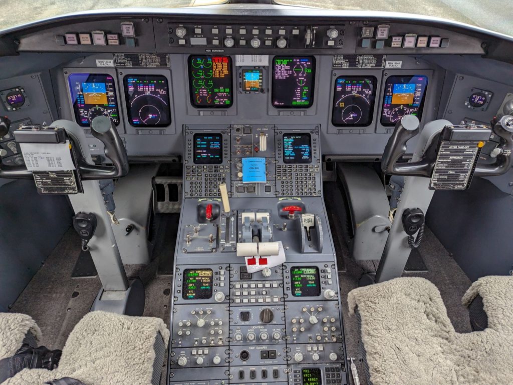 Close-up of a modern aircraft cockpit showcasing advanced control panels and displays.
