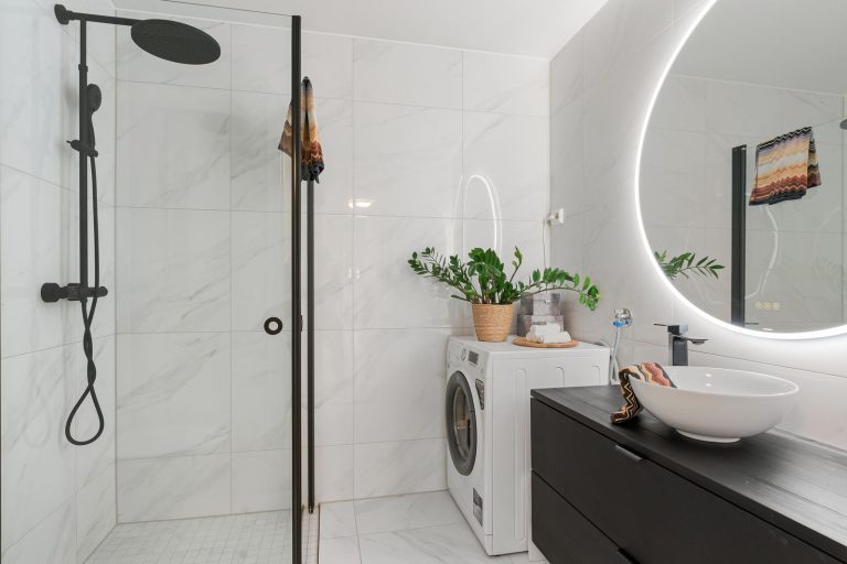 Elegant bathroom interior featuring a minimalist design with shower and laundry area.