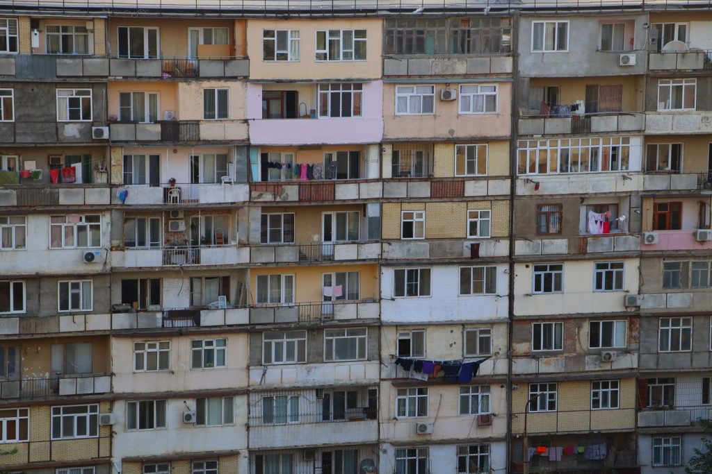 A close-up view of a worn apartment building facade with clothes hanging on balconies.