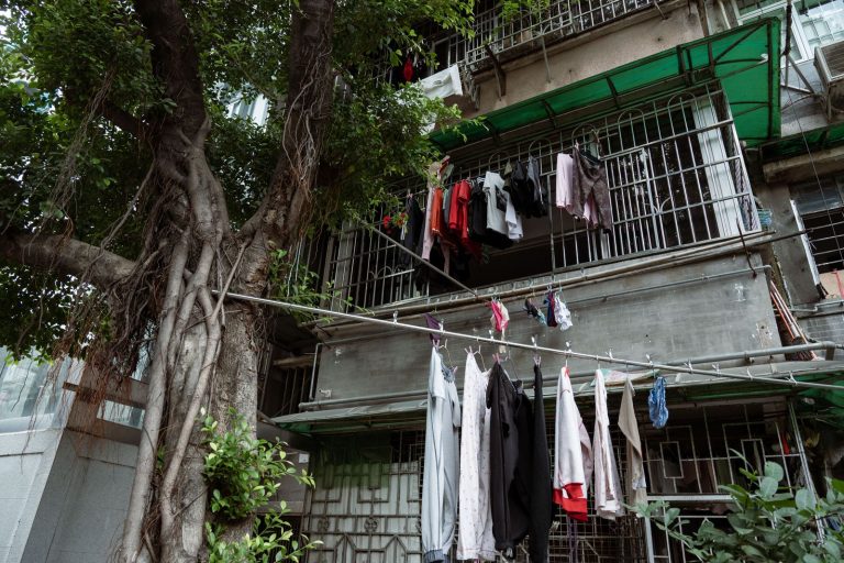 Clothes hanging to dry on a balcony in Guangzhou, China, showcasing local urban lifestyle.