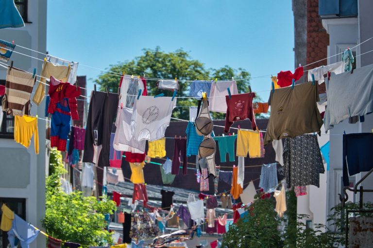Vibrant laundry hanging across a sunny courtyard in Augsburg, Germany.