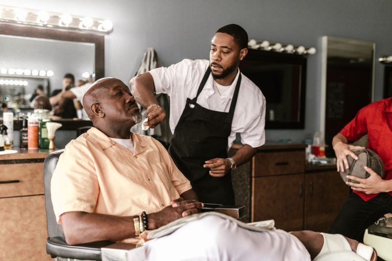 Barber working on a client's haircut in a modern barbershop. Candid indoor scene.