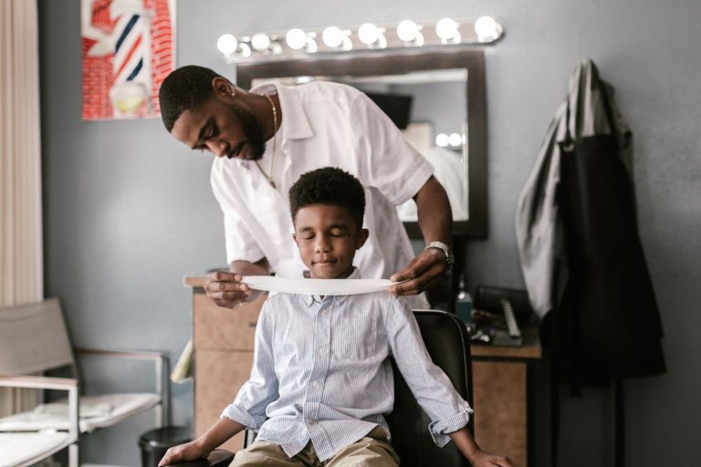 A barber prepares a young boy for a haircut in a stylish barbershop.