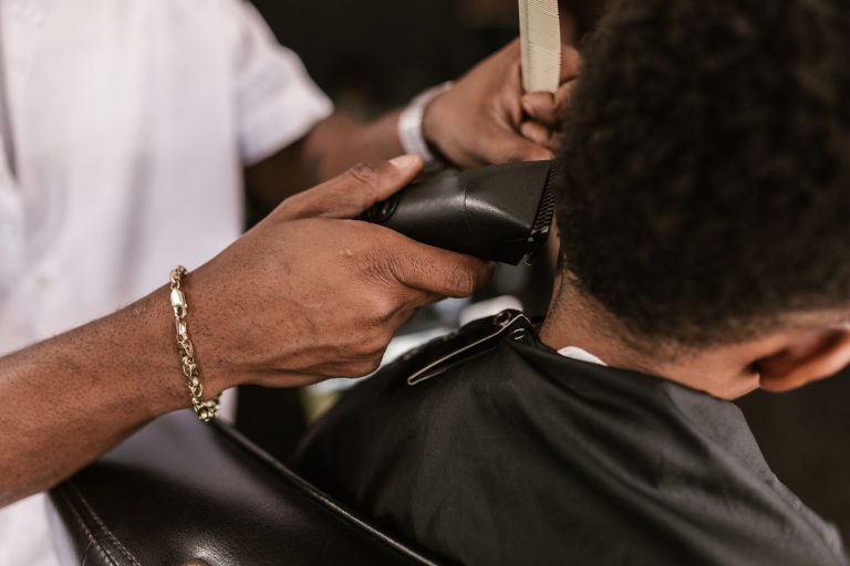 Close-up of a barber using clippers on a child's hair for a precise haircut.