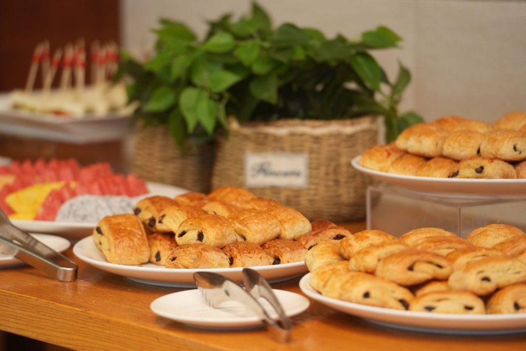A delectable display of pastries including chocolate croissants on a buffet table, ideal for breakfast events.