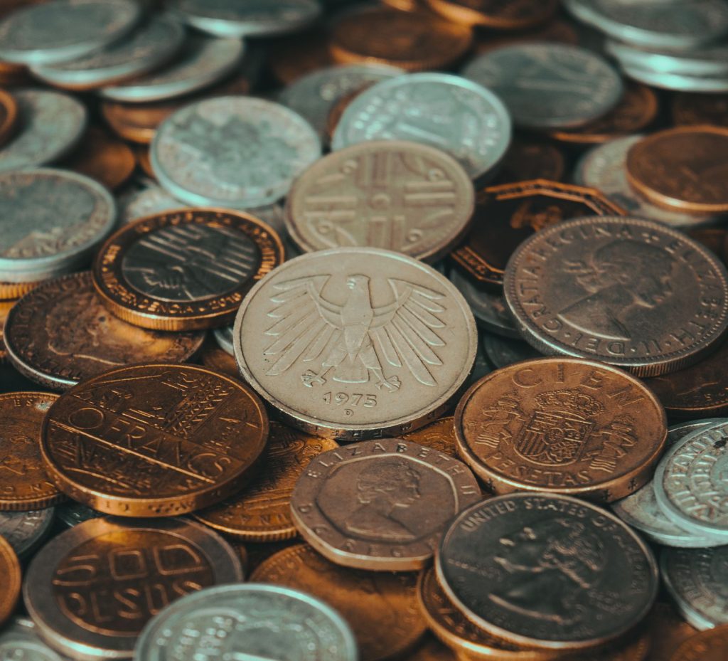 Close-up of various international coins, showcasing diverse currency designs and historical significance.