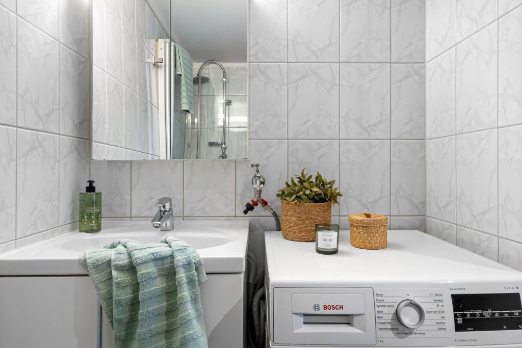 A clean and modern bathroom with integrated laundry area and elegant decor.