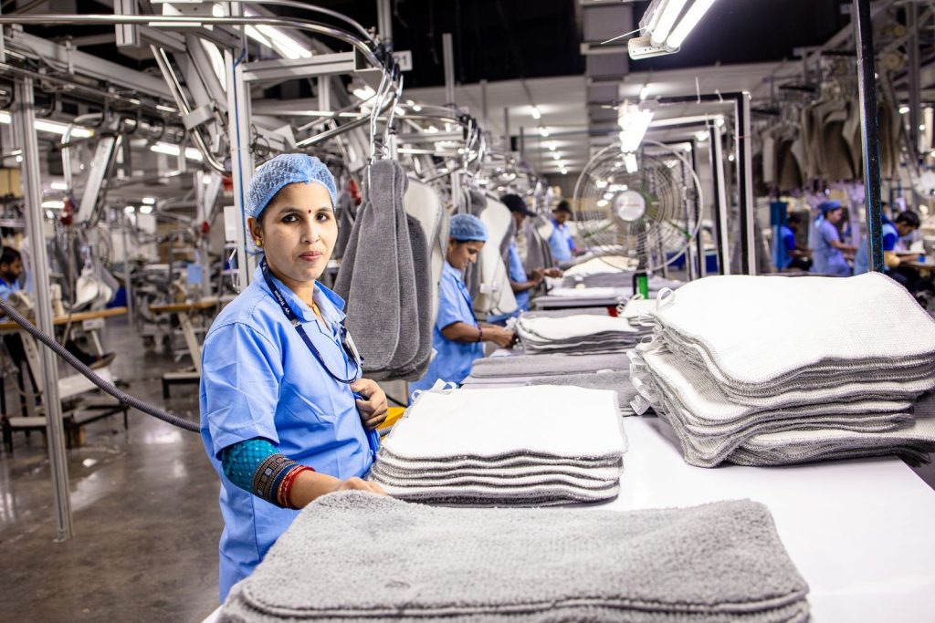 Factory workers in a textile mill in India processing fabric materials.
