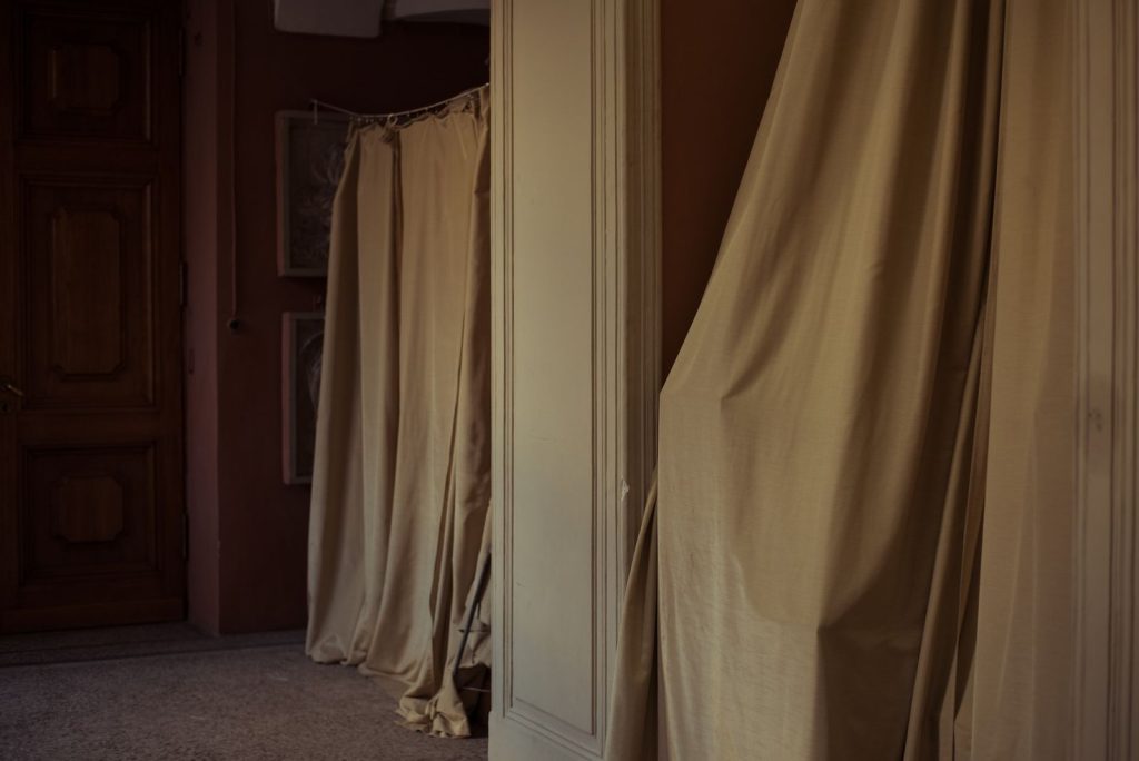 An elegant indoor scene featuring draped curtains and a classic wooden door in a calm setting.