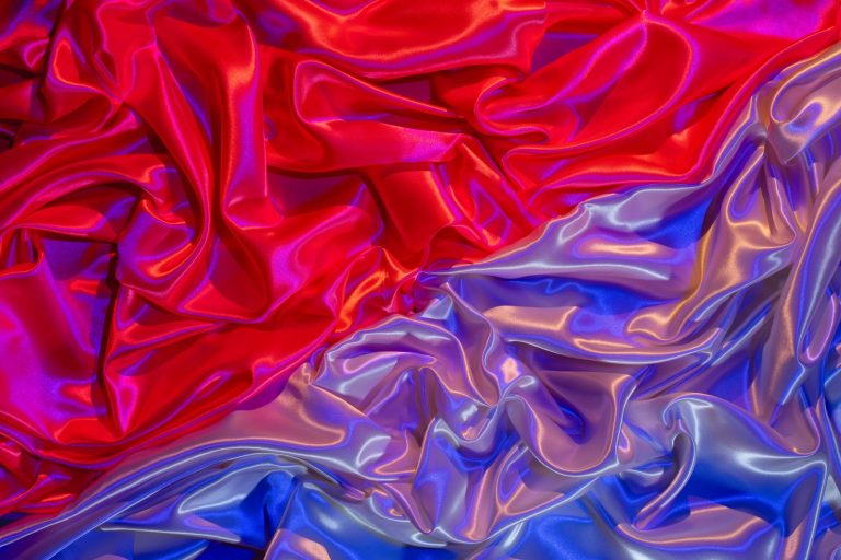 Colorful silky fabric in vibrant red and blue with glossy textures and ripples.
