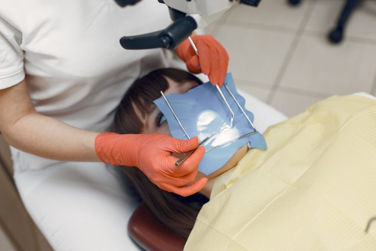 Close-up of a dental procedure with dentist using equipment in clinic.