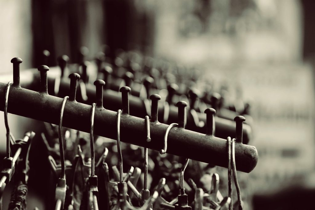 Stylish black and white photo of metal hangers neatly arranged on a rack, perfect for design concepts.
