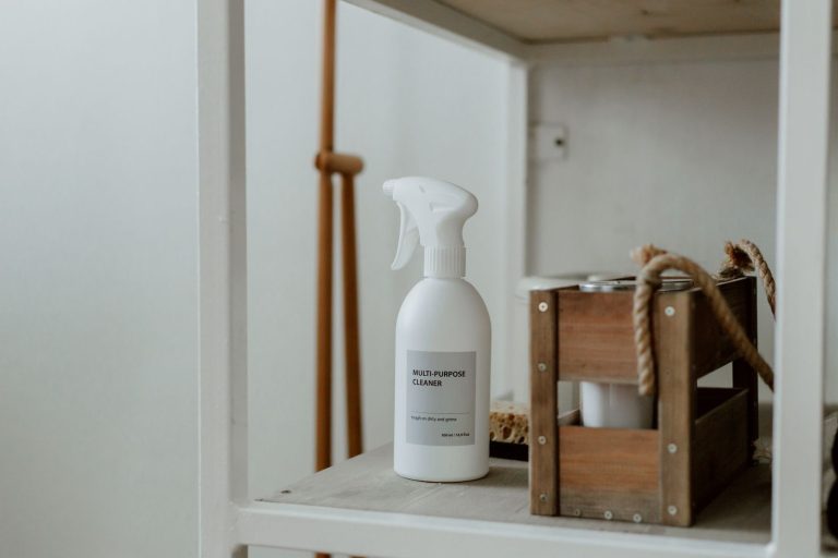 Clean white shelf with a spray cleaner and wooden caddy, perfect for home organization.