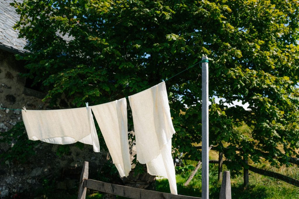 Linen sheets hanging on a clothesline outdoors in the French countryside.